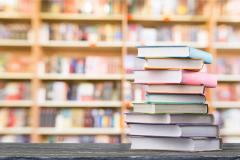 pile de livres avec en fond une bibliothèque