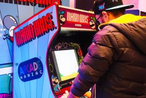jeune homme qui joue sur une borne d'arcade