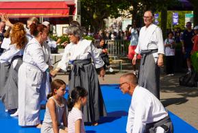 Personnes pratiquant le kinomichi vêtus du keikogi, sur un tatami bleu