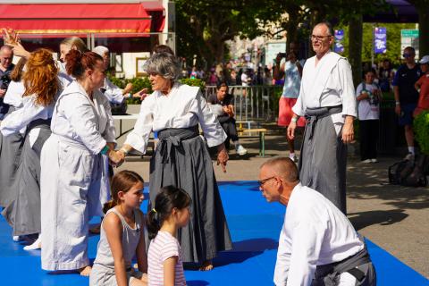 Personnes pratiquant le kinomichi vêtus du keikogi, sur un tatami bleu