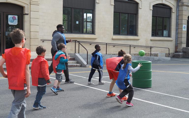 Photo représentant des enfants jouant au basket dans une cour