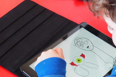 Photo d'un enfant dessinant sur une tablette