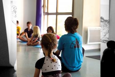 Photo représentant un professeur enseignant le yoga à des enfants